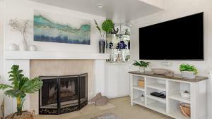 a living room with a fireplace and a flat screen tv at Shoreline Villa by AvantStay Steps to the Beach Bay Pier in Newport Beach