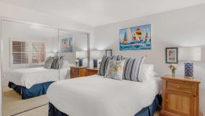 a white bedroom with two beds and a window at Shoreline Villa by AvantStay Steps to the Beach Bay Pier in Newport Beach