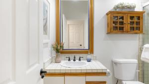 a bathroom with a sink and a mirror and a toilet at Shoreline Villa by AvantStay Steps to the Beach Bay Pier in Newport Beach +46 photos