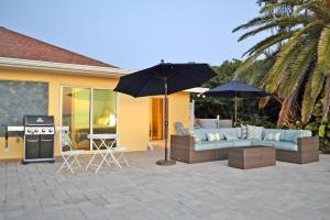 a patio with a couch and an umbrella and a grill at 8730 Dunmore Dr in Vamo