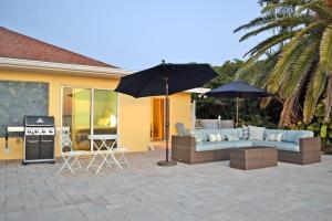 a patio with a couch and an umbrella and a grill at 8730 Dunmore Dr in Vamo