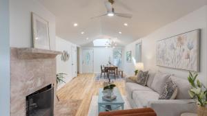 a living room with a couch and a fireplace at Conch Cottage by AvantStay Walk to Beach Deck Fireplace Outdoor Dining in Isle of Palms