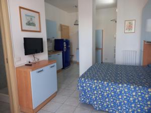 a bedroom with a bed and a tv on a dresser at Hotel Residence Il Conero 2 in Numana +7 photos