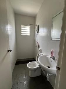 a white bathroom with a toilet and a sink at Bloomy Homestay Bertam Kepala Batas in Kepala Batas