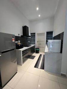 a kitchen with white walls and a white floor at Bloomy Homestay Bertam Kepala Batas in Kepala Batas