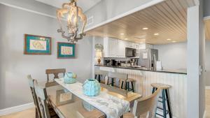 a dining room and kitchen with a table and chairs at 407 A Shipwatch by AvantStay Beach Front Condo w Ocean Views in Isle of Palms