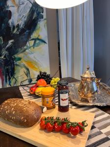 a cutting board with a loaf of bread and vegetables at Residenz am Dreiländereck in Vaals