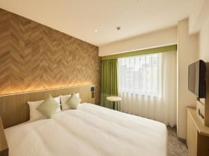 a bedroom with a white bed and a television at Villa Fontaine Tokyo Otemachi in Tokyo +18 photos