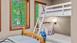 a bunk bed room with two bunk beds and a window at The Great Escape by AvantStay Game Room in Albrightsville