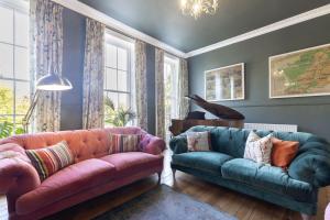 a living room with two couches and a piano at Luxury 4-Bed Regency Townhouse Overlooking Montpellier Gardens in Cheltenham