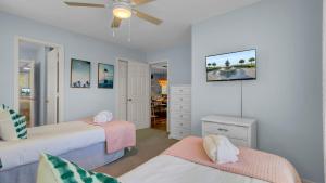 a bedroom with two beds and a ceiling fan at Ion by AvantStay Walk to Beach Dining Shopping Central Location Deck in Sullivans Island