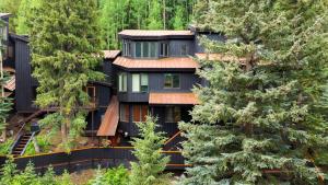 una casa en el bosque con árboles en Manitou River House 113 by AvantStay A Location, en Telluride