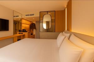 a bedroom with a large white bed with pillows at Golden Tulip Avignon Le Paradou in Avignon