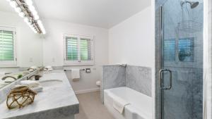 a white bathroom with a shower and a sink at East Valley Manor by AvantStay Minutes to the Beach in Montecito +30 photos