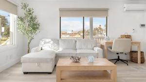 a living room with a white couch and a table at Steps to the Beach 2 Units w Patio Fire Pit Pacific Coast Highway Buyout in Huntington Beach