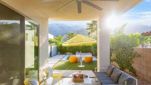 a patio with an umbrella and a table and chairs at Marilyn by AvantStay Mins to Old Town La Quinta in La Quinta
