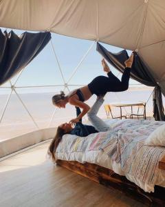 a woman is standing on top of a bed at Rum prens in Wadi Rum