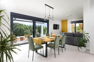 a dining room and living room with a table and chairs at Villa Japlenica by Istrialux in Žagrići