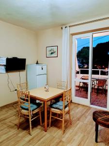 ein Esszimmer mit Tisch und Stühlen und einem Fernseher in der Unterkunft Apartmani TOPLA - Zlokovic - apartman A3 i apartman A4 in Topla