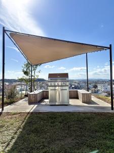 a oven under a canopy on top of a hill at 大洗の眺望抜群なコンテナハウス #一棟貸切 #本格BBQ #大型ガスグリル完備 #大洗 #OURoom1st in Oarai