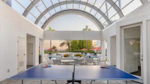 an indoor ping pong court in a house with a glass ceiling at La Paloma by AvantStay Large Private Patio PoolHot TubTennis Court Access in Dana Point