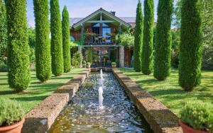 a garden with a fountain in front of a house at ÜbermAlztal Gartenblick in Altenmarkt an der Alz