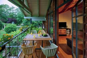 a patio with a table and chairs on a balcony at ÜbermAlztal Gartenblick in Altenmarkt an der Alz