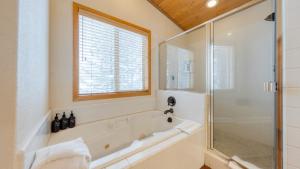 un bagno con vasca e doccia in vetro di Oslo Haus by AvantStay Cabin Retreat Near Northstar Downtown Truckee a Truckee Altre 33 foto