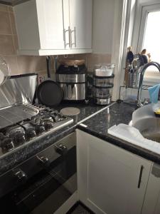 una cocina con estufa y encimera en Sunflower Shared Apartment, en Londres