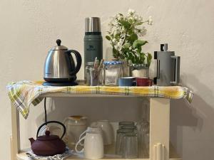 a shelf with a tea kettle and other items on it at The Luxury Loft in Montagu +5 photos