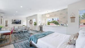 a bedroom with a bed and a kitchen and a dining room at Pink Revival Historic Remodeled Bungalows Heart of Hollywood in Los Angeles