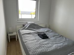 a bed in a room with a window at Apartament Brama Pomorza in Chojnice