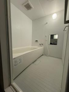 a white bathroom with a tub and a sink at guest house Sakura in Osaka +23 photos