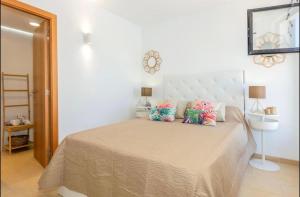 een slaapkamer met een groot bed met kussens erop bij Sa Perdiu 30 Apartment in Son Carrio