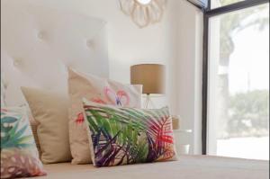 een groep kussens op een bed met een raam bij Sa Perdiu 30 Apartment in Son Carrio +21 foto's