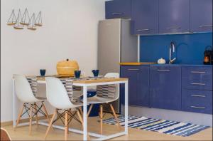 een keuken met blauwe kasten en een tafel en stoelen bij Sa Perdiu 30 Apartment in Son Carrio