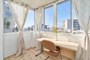 una scrivania in una stanza con finestre con un vaso di fiori di Casa Ramos Con Jacuzzi a Nerja