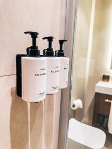 a bathroom with three soap dispensers on a wall at Liv Hotels Erciyes in Cebir
