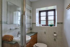 a bathroom with a sink and a toilet and a window at Finest Retreats - Town Farm Cottage in Exbourne +26 photos