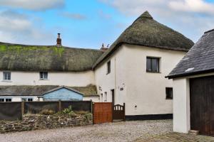 a group of houses with a thatched roof at Finest Retreats - Town Farm Cottage in Exbourne