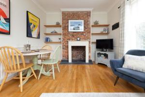 a living room with a table and a fireplace at Characterful City Maisonette for 4 in Chichester