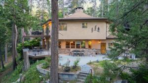 una casa grande en medio de un bosque en The Fairway Hideaway Game Room Outdoor Dining Near Lake Arrowhead, en Lake Arrowhead