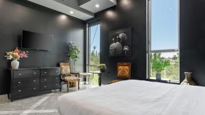 a bedroom with a large bed and a tv at Luxe LA Escape w Pool Views Game Room Alta Vista Estate by AvantStay in Los Angeles +59 photos