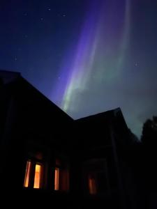 una casa con la aurora en el cielo en Lapland Dream Destinations, en Rovaniemi