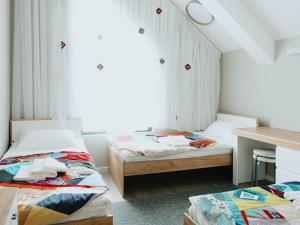 a bedroom with two beds and a table and a desk at Skeramos Boutique Art Hotel in Bishkek