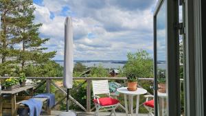 a balcony with a table and chairs and a view of the water at Cottage with sea view at Tjorn Island in Stora Dyrön