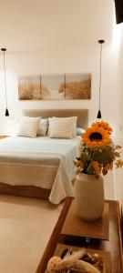 a bedroom with a bed and a vase with flowers at Estudio centro de La Laguna in La Laguna