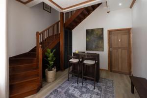 a room with a bar with stools and a staircase at De Waterkant Place in Cape Town
