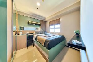 a bedroom with a bed and a small kitchen at Eazystay Gateway Pasteur Apartment in Bandung +171 photos