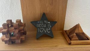 a wooden star with a sign that reads all you need is love at Radiki in Gennadi